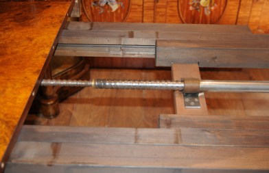 Setting up the leaf system on a walnut Victorian dining table